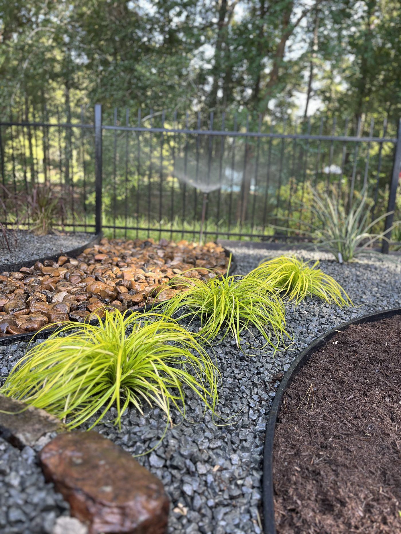 River rock and ornamental grass landscape bed Houston TX