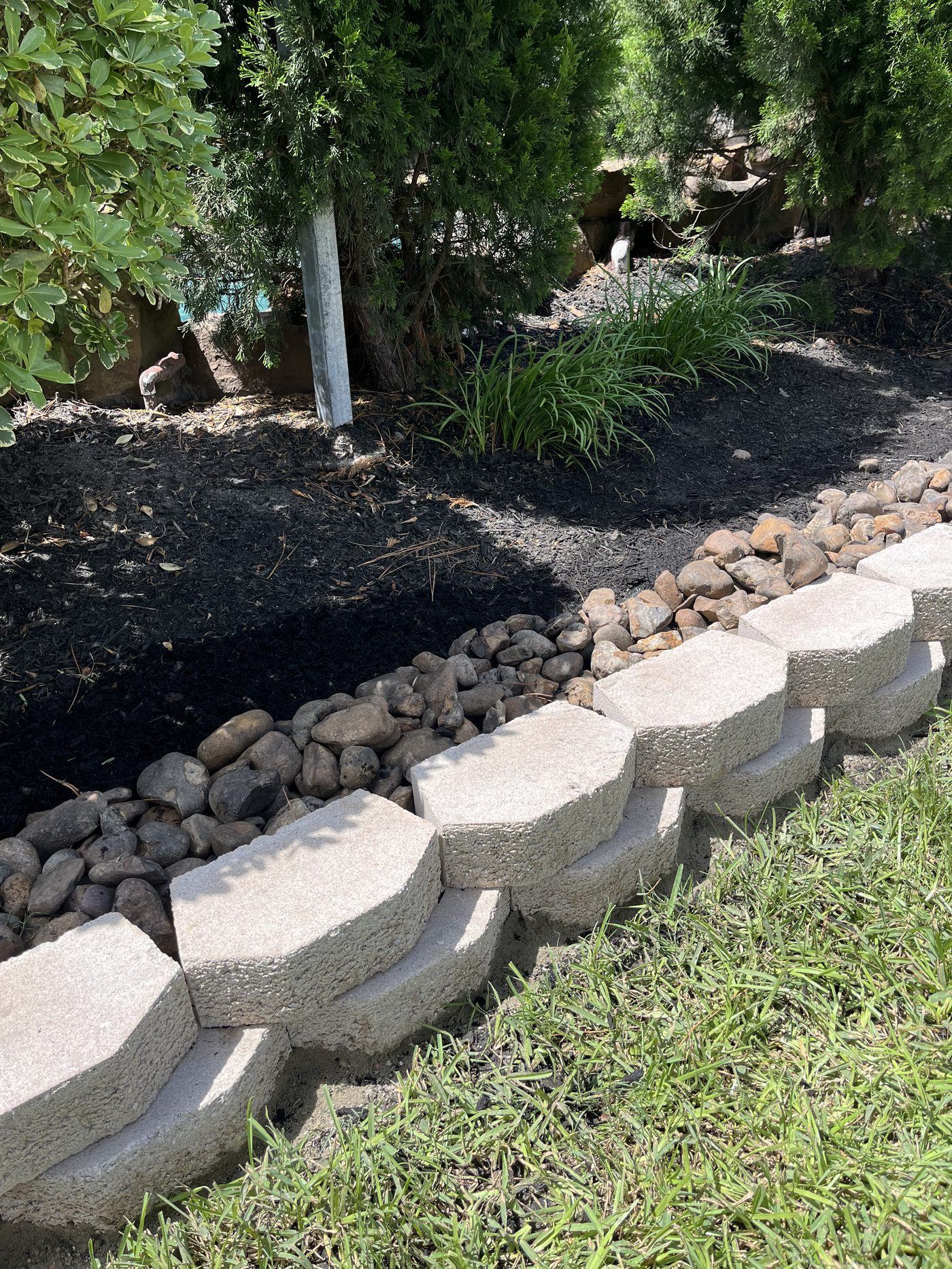 Curved retaining wall border with river rock Houston TX