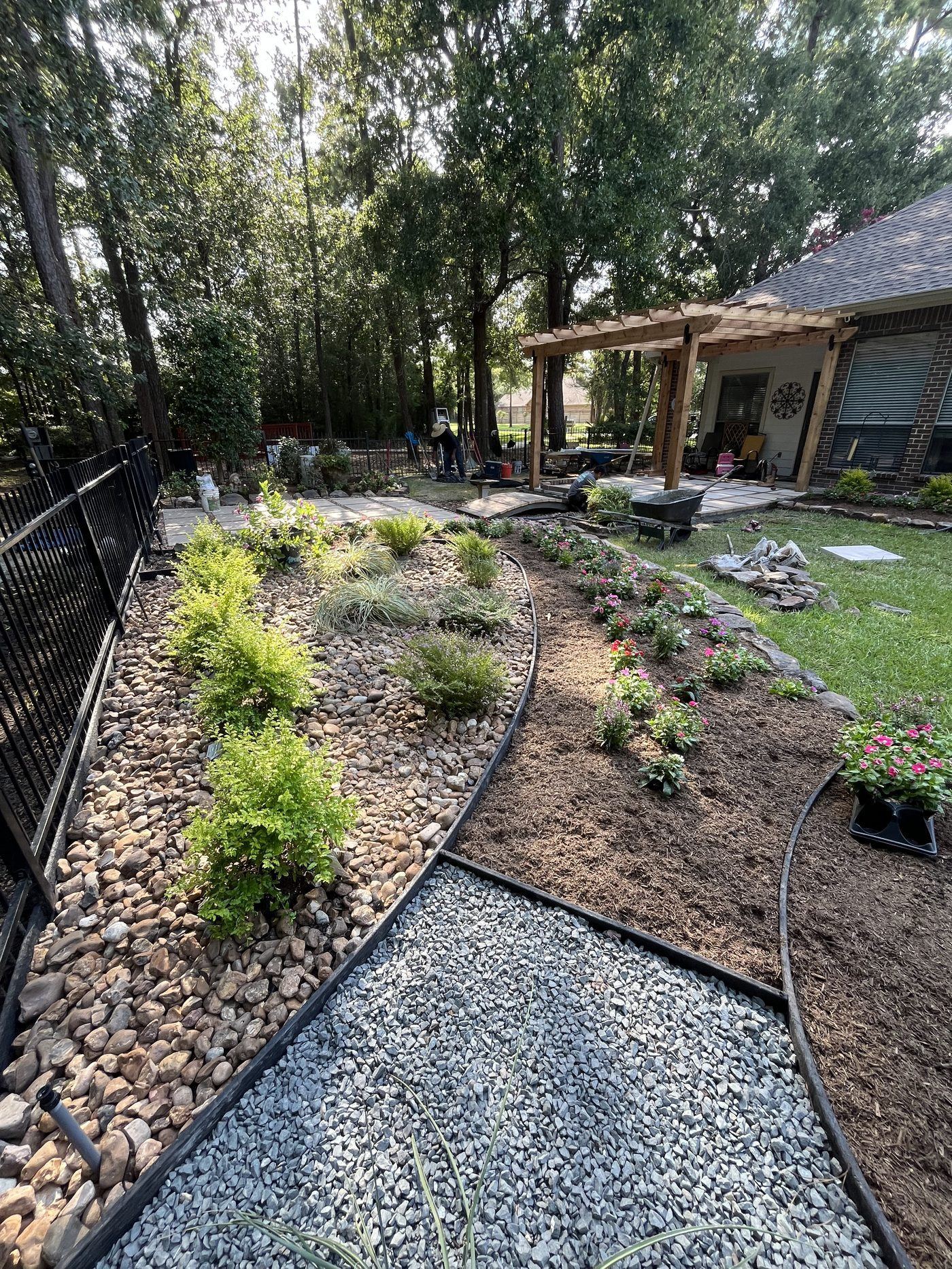 Full backyard landscape install with river rock and mulch beds Kingwood TX