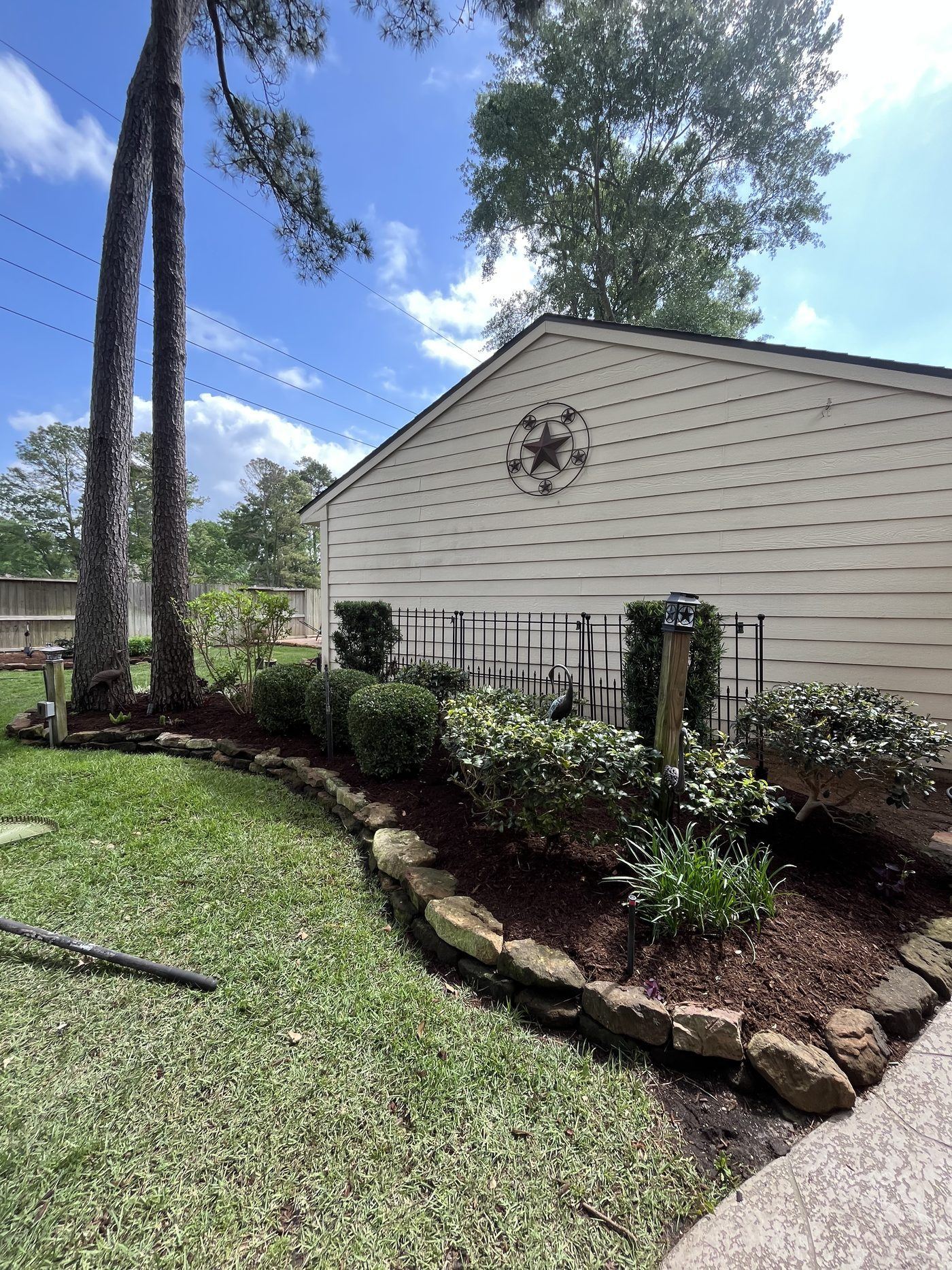 Landscape bed with rock border and shrubs Houston TX