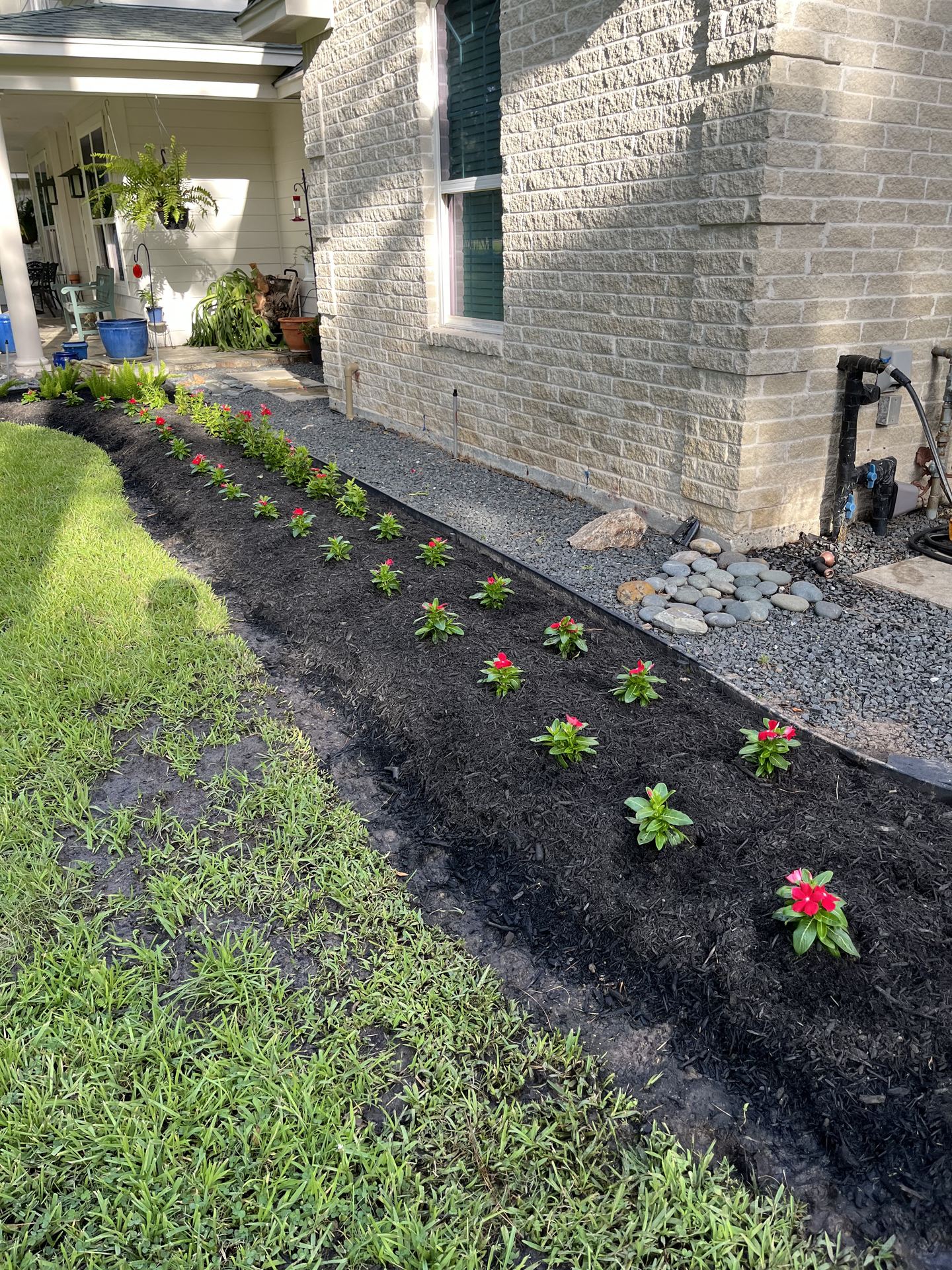 Red vinca flower bed installation Houston TX