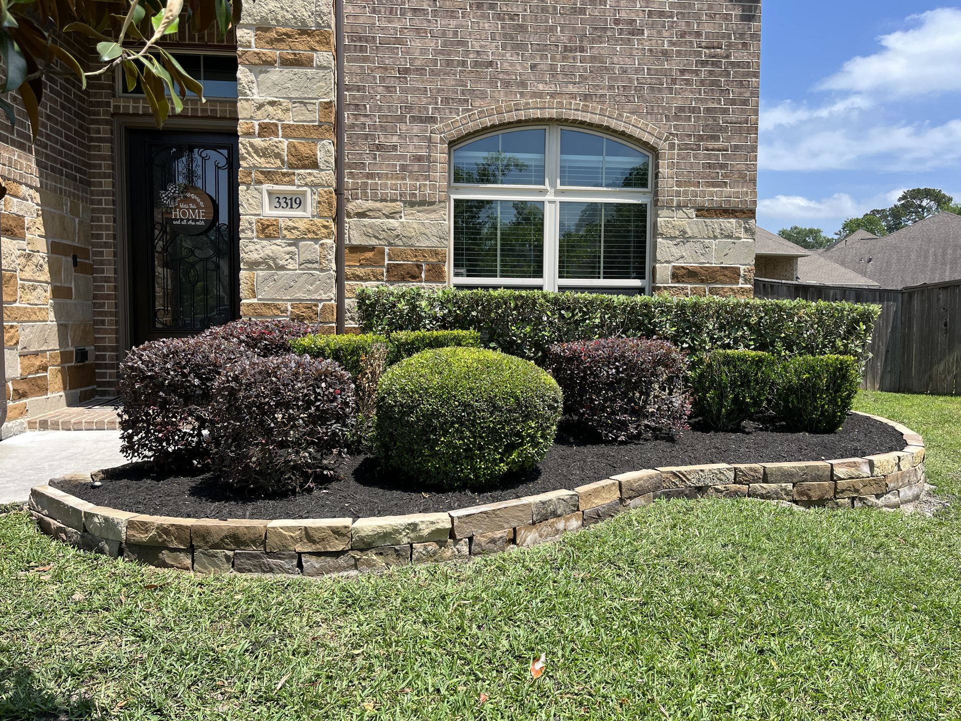 Stone retaining wall entry planting bed Houston TX